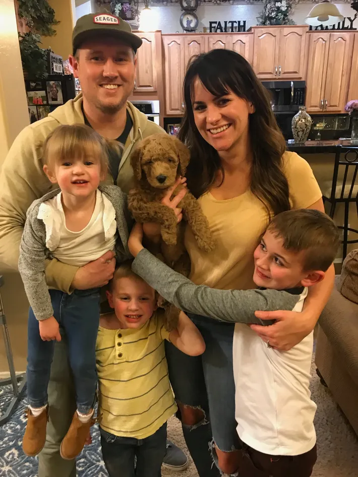 Family of five with brown puppy
